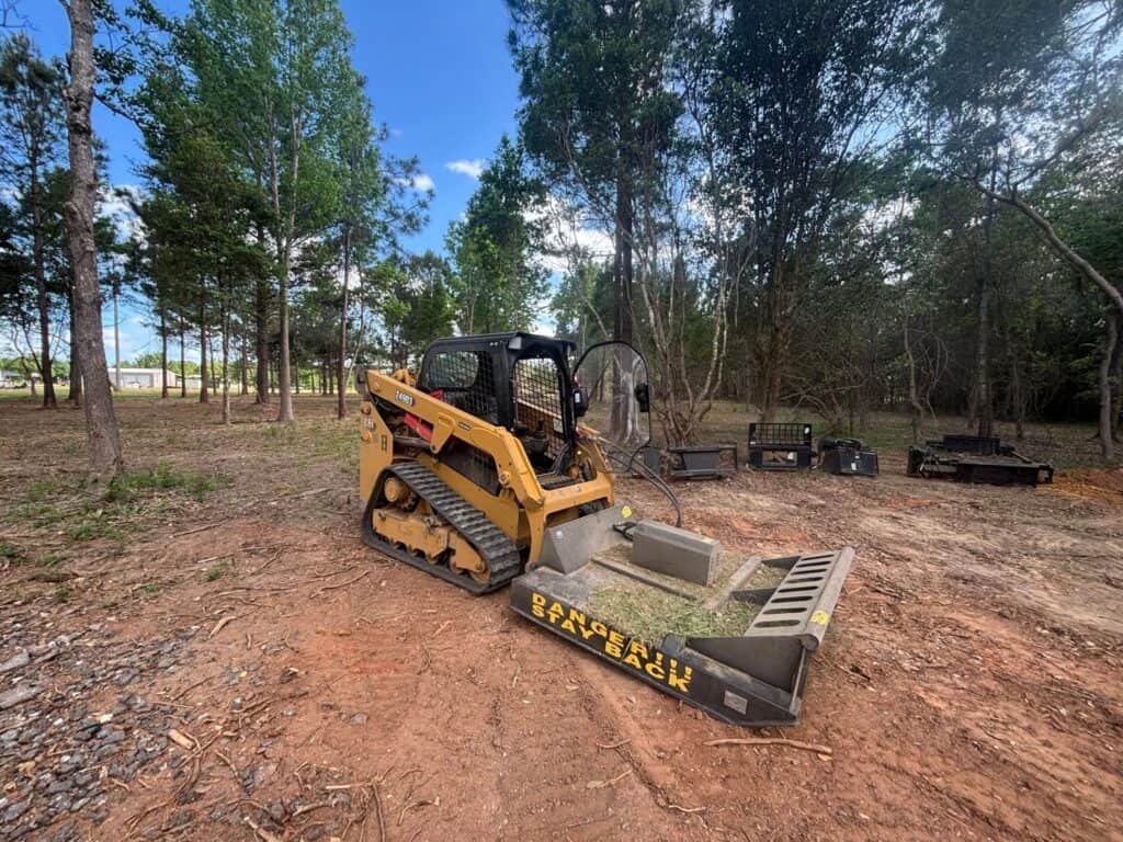 Skid steer preparing a wooded property for landscaping work