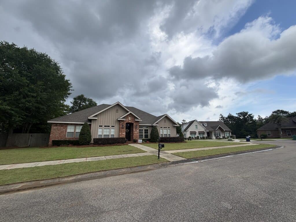 Suburban homes with neatly maintained lawns, planted beds, and sidewalk landscaping